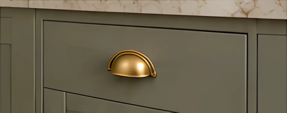 Sage drawer front with a brass cup handle